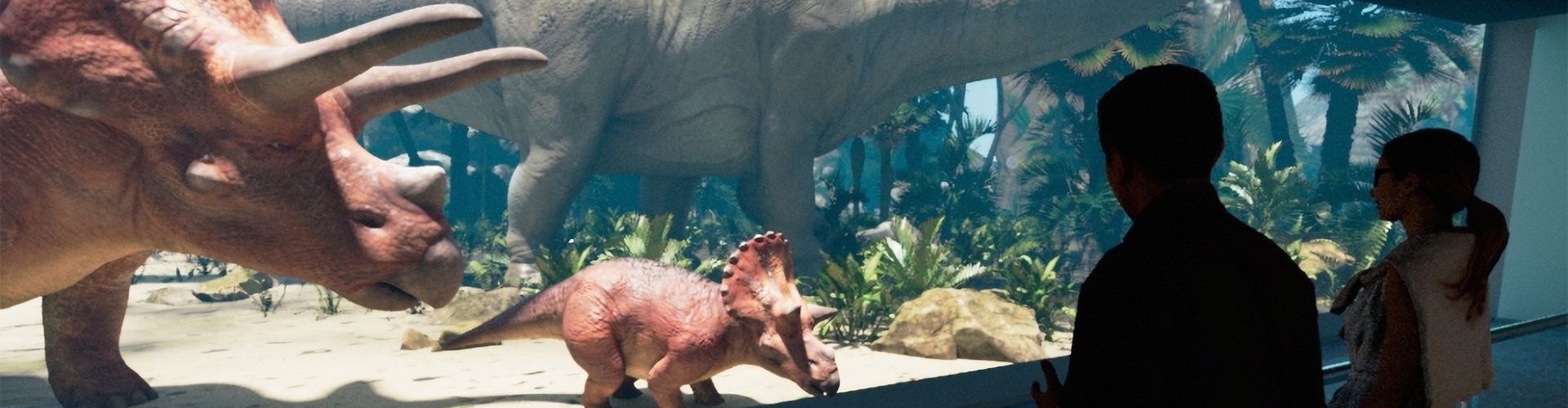 Dinosaurs looking over zoo visitors